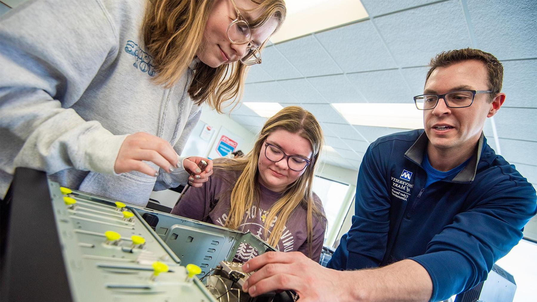 Students breaking down a computer